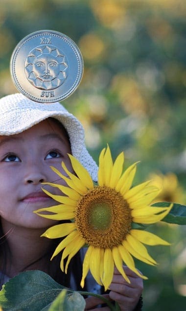 Young girl with sunflowers and tarot coin